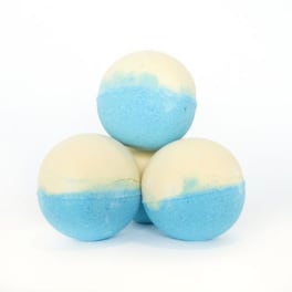 Three blue and cream bath bombs stacked on a white background