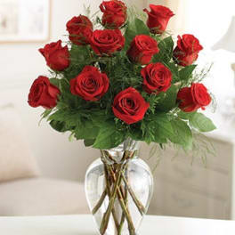 Red roses arranged in a clear glass vase