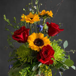 Tall bouquet with red roses and yellow sunflowers in a rustic wood base