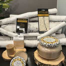 Candle and fragrance gift items arranged on wood slices with white birch logs