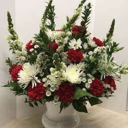 Red and white floral arrangement in a white vase