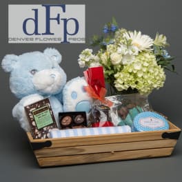 Gift basket with a flower arrangement, teddy bear, chocolates, and soap