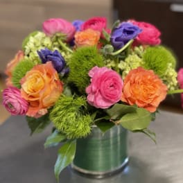 Colorful bouquet of ranunculus in a green vase