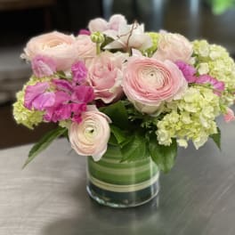 Pink and white flowers arranged in a glass vase