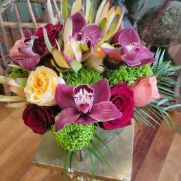 Mixed bouquet with orchids, roses, and green chrysanthemums in a vase