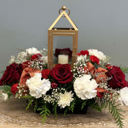 Red and white floral arrangement with a lantern centerpiece