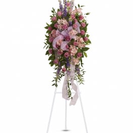 Standing floral spray of pink roses and lavender flowers on an easel
