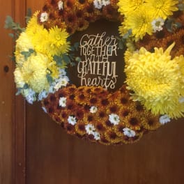 Chrysanthemum wreath with a "Gather Together with Grateful Hearts" sign