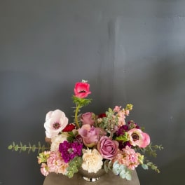 Mixed pink and purple flower arrangement in a silver vase