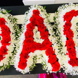 Red and white floral letters arranged on a black surface