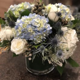 Blue hydrangea and white rose bouquet in a glass vase