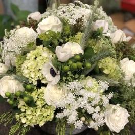 White roses and pale green hydrangeas in a round bouquet