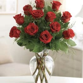 Red roses arranged in a clear glass vase