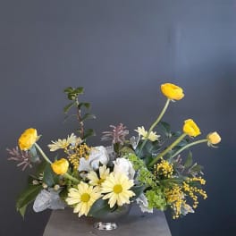 Yellow and white floral arrangement in a dark vase