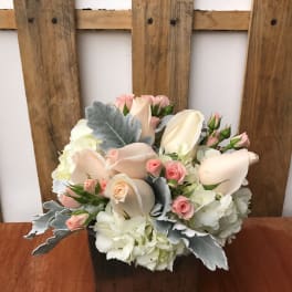 Pastel roses and hydrangeas arranged in a wooden box