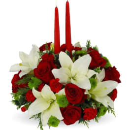Red roses and white lilies arranged with two red taper candles