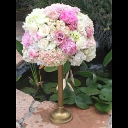 Pink and white floral arrangement on a gold stand
