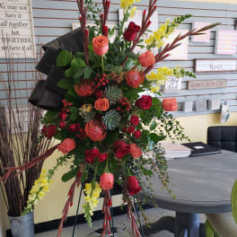 Tall floral arrangement with roses, snapdragons, and succulents