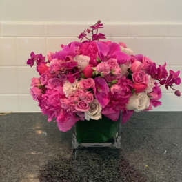 Pink and white floral arrangement in a square glass vase