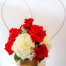 Red roses and white hydrangeas in a gold box with heart wire accents