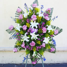 Standing floral spray with pink and white lilies on an easel