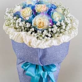 Bouquet of pastel roses with baby's breath in blue wrapping