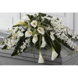 White calla lilies and orchids arranged on a casket