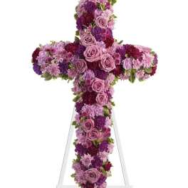 Purple and pink floral cross on a white stand