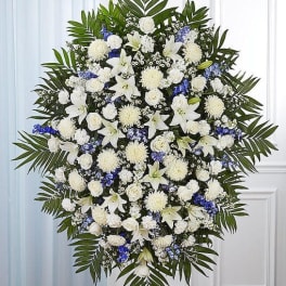 Large white and blue funeral spray with lilies and roses