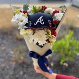 Bouquet with white and red flowers around a navy baseball cap