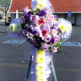 Large purple and white floral cross on a stand