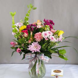 Mixed bouquet in a textured glass vase with a plaid ribbon