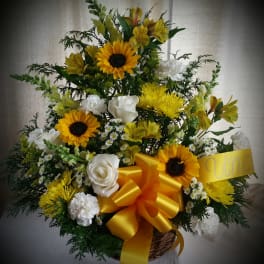 Basket arrangement of yellow sunflowers and white roses with a large yellow bow