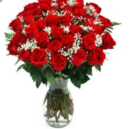 Bouquet of red roses with baby's breath in a clear glass vase