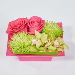 Pink roses and green orchids in a pink box