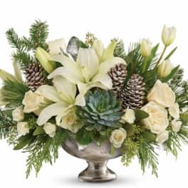 White lilies and roses in a silver pedestal bowl with pinecones