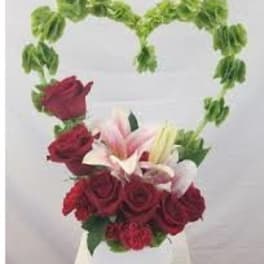 Heart-shaped floral arrangement with red roses and lilies