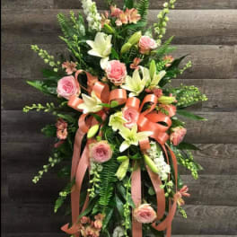 Tall floral standing spray with pink roses, white lilies, and peach ribbon