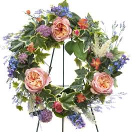 Floral wreath with pink roses, purple blooms, and mixed greenery
