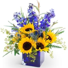Sunflowers and blue flowers in a cobalt glass vase