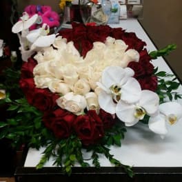 Heart-shaped rose arrangement with white orchids and greenery