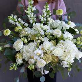 Large white floral arrangement with roses and hydrangeas