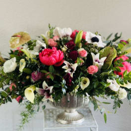 Large mixed floral arrangement in a silver urn vase