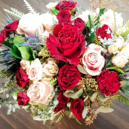 Bouquet of red and blush roses with mixed greenery