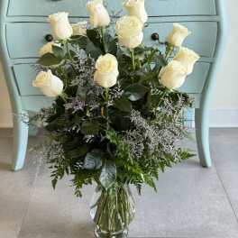 White roses arranged in a clear glass vase