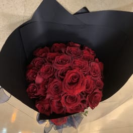 Bouquet of red roses wrapped in black paper