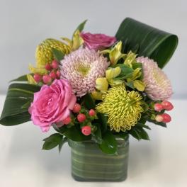 Pink roses and chrysanthemums in a square glass vase