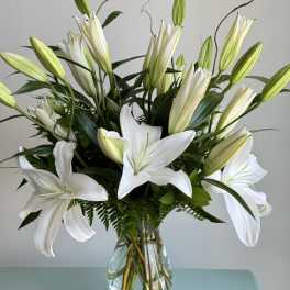 White lilies arranged in a clear glass vase