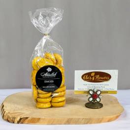 Bag of yellow emoji chocolates on a wood slab with a decorative business card holder