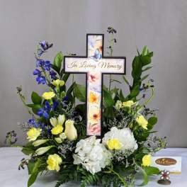 Memorial floral cross with white and yellow flowers and blue accents